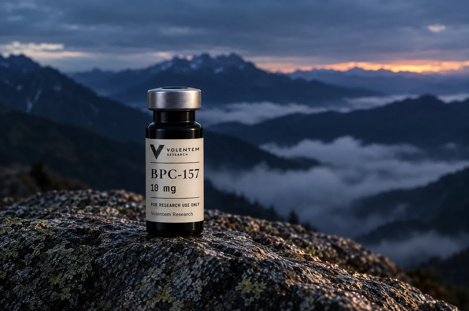 A Volentem Research vial standing on a lichen-covered summit rock above a sea of cloud at dusk